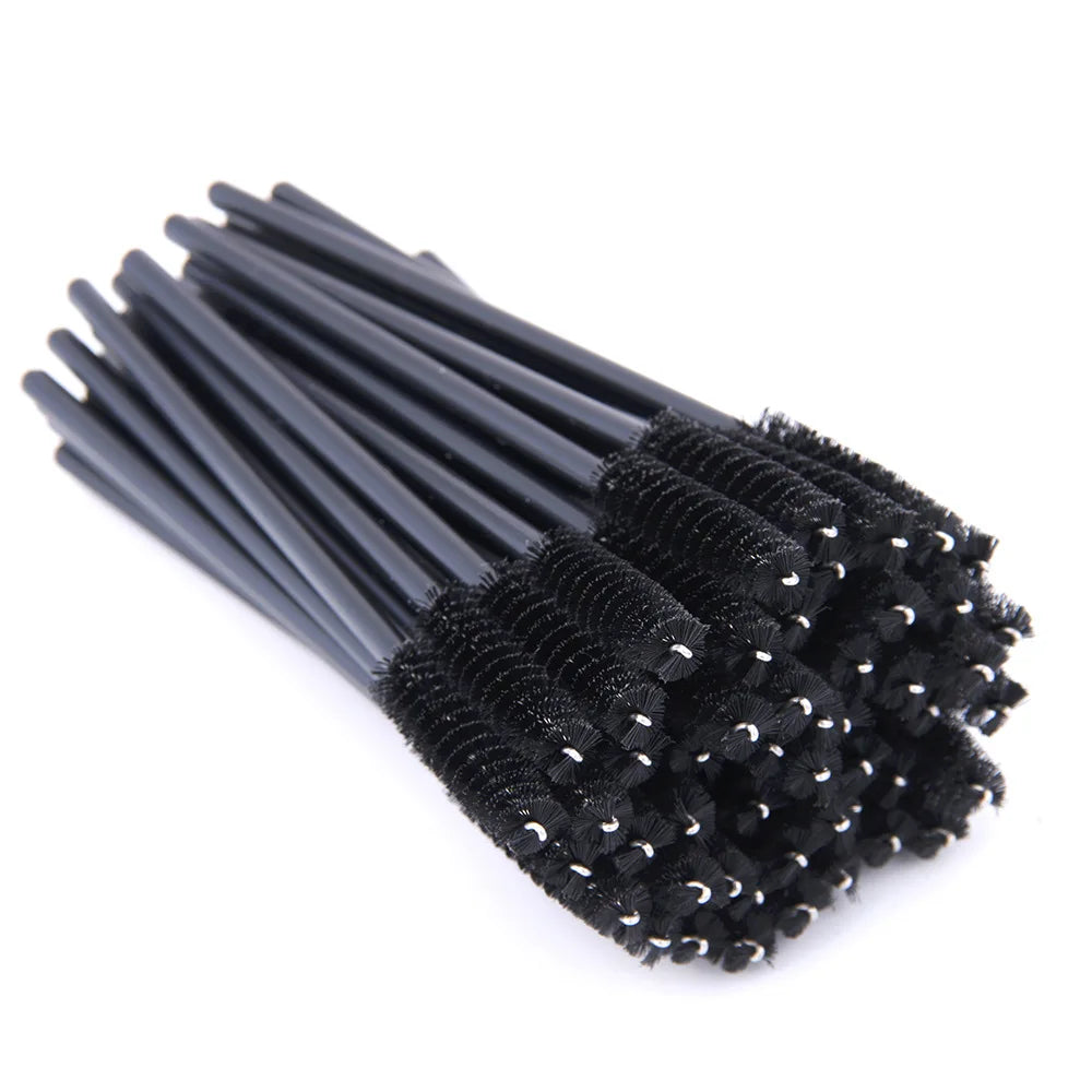 A bundle of black plastic disposable eyelash spoolie brushes for applying mascara or grooming eyebrows.
