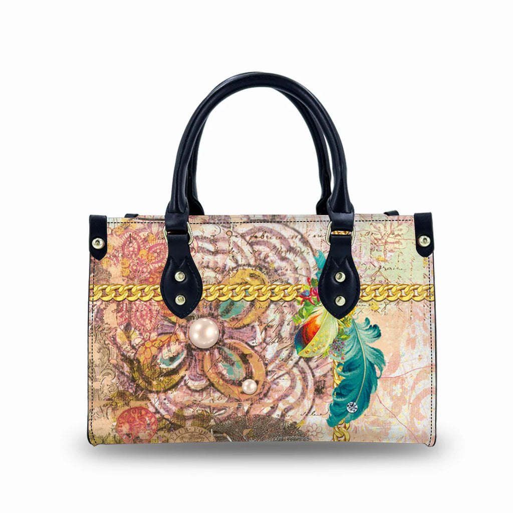 Vintage leather handbag with black handles, artistic floral print, gold chain detail, and pearl accents. Trunk style.