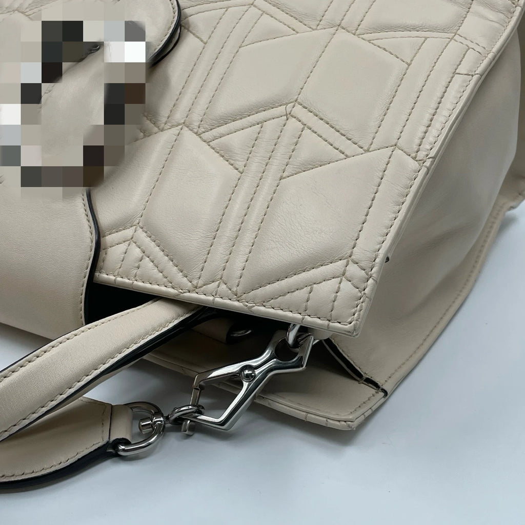 Chic white leather designer handbag with geometric quilted pattern, silver hardware, and structured shoulder tote style.