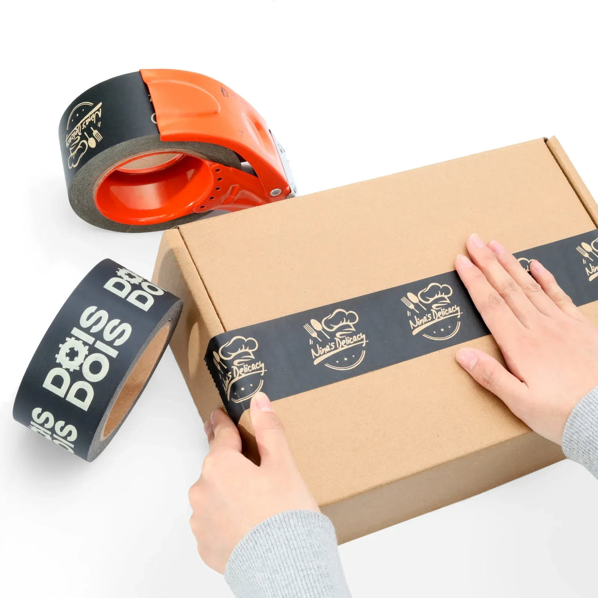 Custom printed black kraft packing tape roll with orange dispenser and sealed box