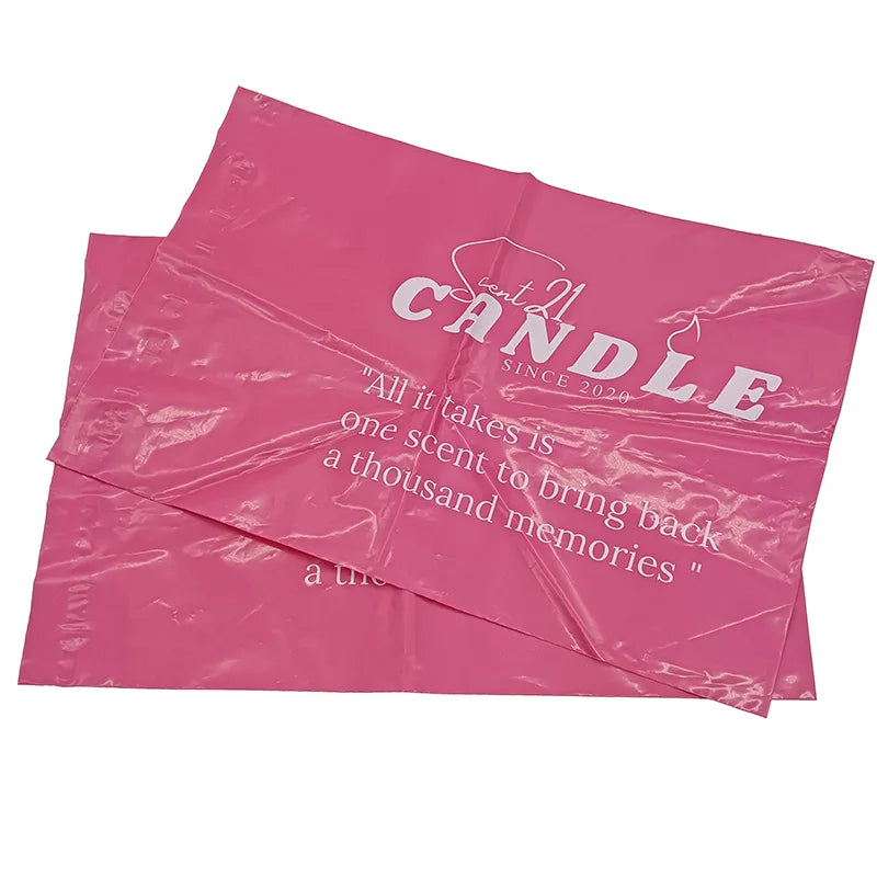Pink printed poly mailer bags stacked, white logo text centered