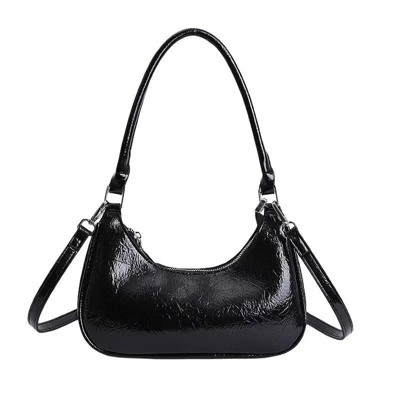 Black glossy patent leather dumpling shoulder bag with top handle and detachable crossbody strap.