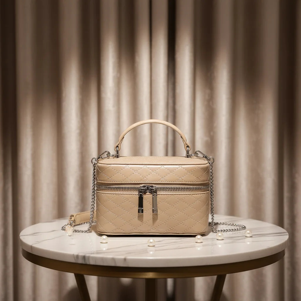 Beige quilted genuine leather trunk box bag with silver hardware, top handle, and detachable chain shoulder strap.