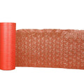 Pink bubble wrap mailer roll with textured air cushioning sheet, curled for packing