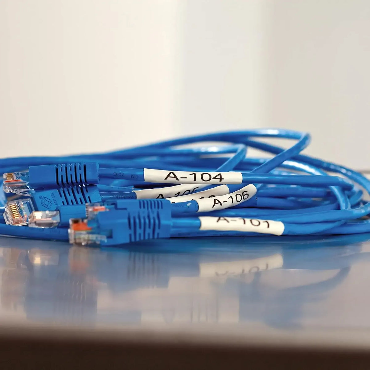 Blue network cables with white heat-shrink labels marked A-104, A-106, and A-101