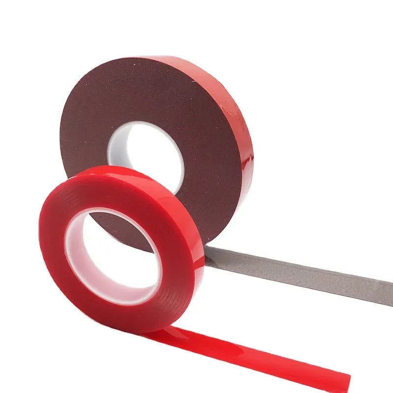 Brown and red double-sided acrylic foam tape rolls stacked with adhesive edge