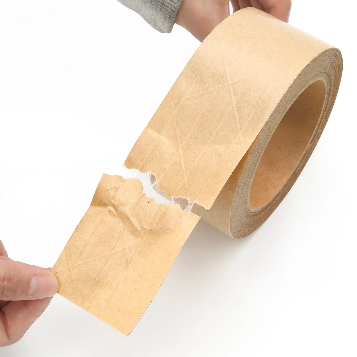 Tan kraft paper packing tape roll with cut strip held by hand