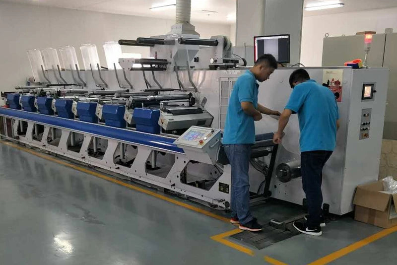 Mailing bag production machine line with workers handling packaging