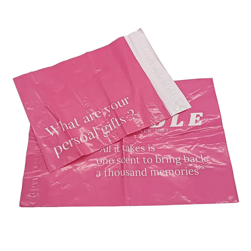 Pink poly mailer bags with white logo and quote text, one bag partially open