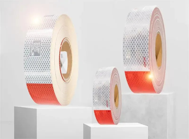 Reflective road safety tape rolls in white, red, and yellow with striped pattern