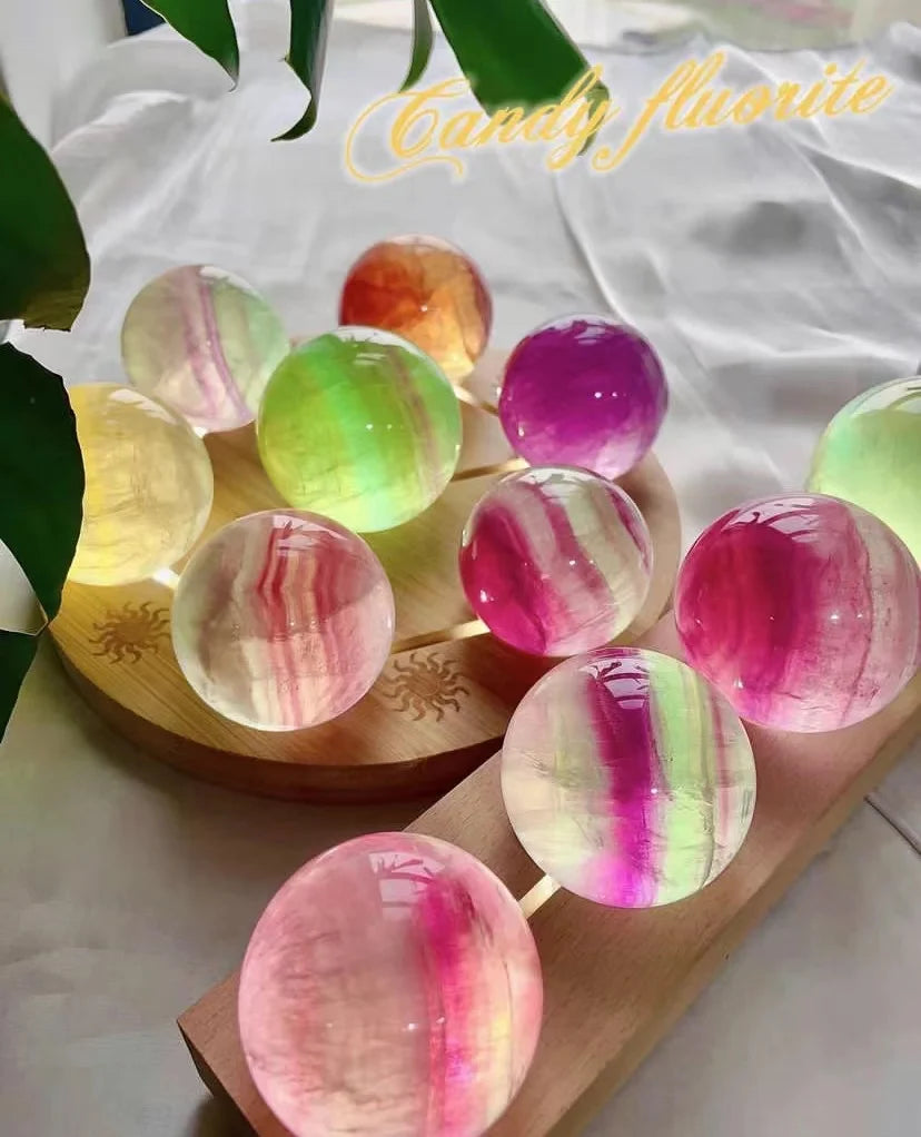 Fluorite crystal spheres displayed on wooden trays, multicolored and glossy.