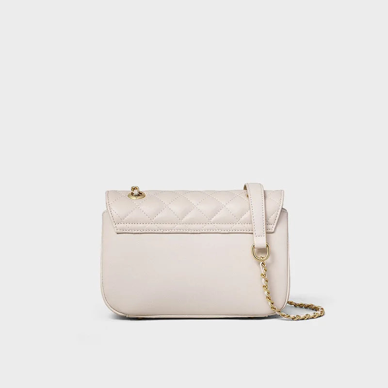 Beige quilted genuine leather shoulder bag with a gold chain strap, turn-lock flap, and trunk-style silhouette.