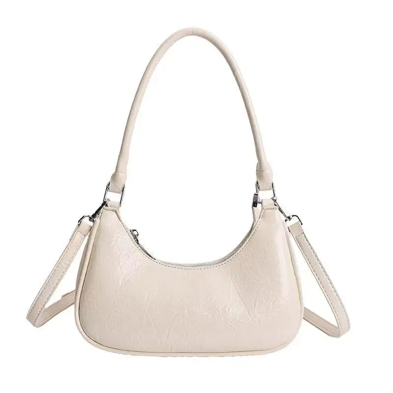 Off-white luxury leather dumpling shoulder bag with crinkled texture, top handle, and detachable crossbody strap.