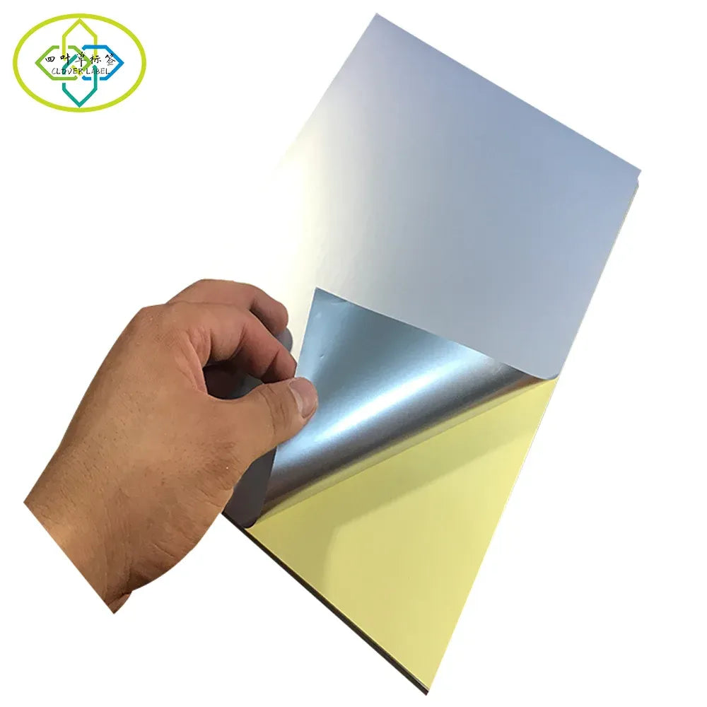 Hand peeling glossy silver self-adhesive PET A4 label sheet from backing