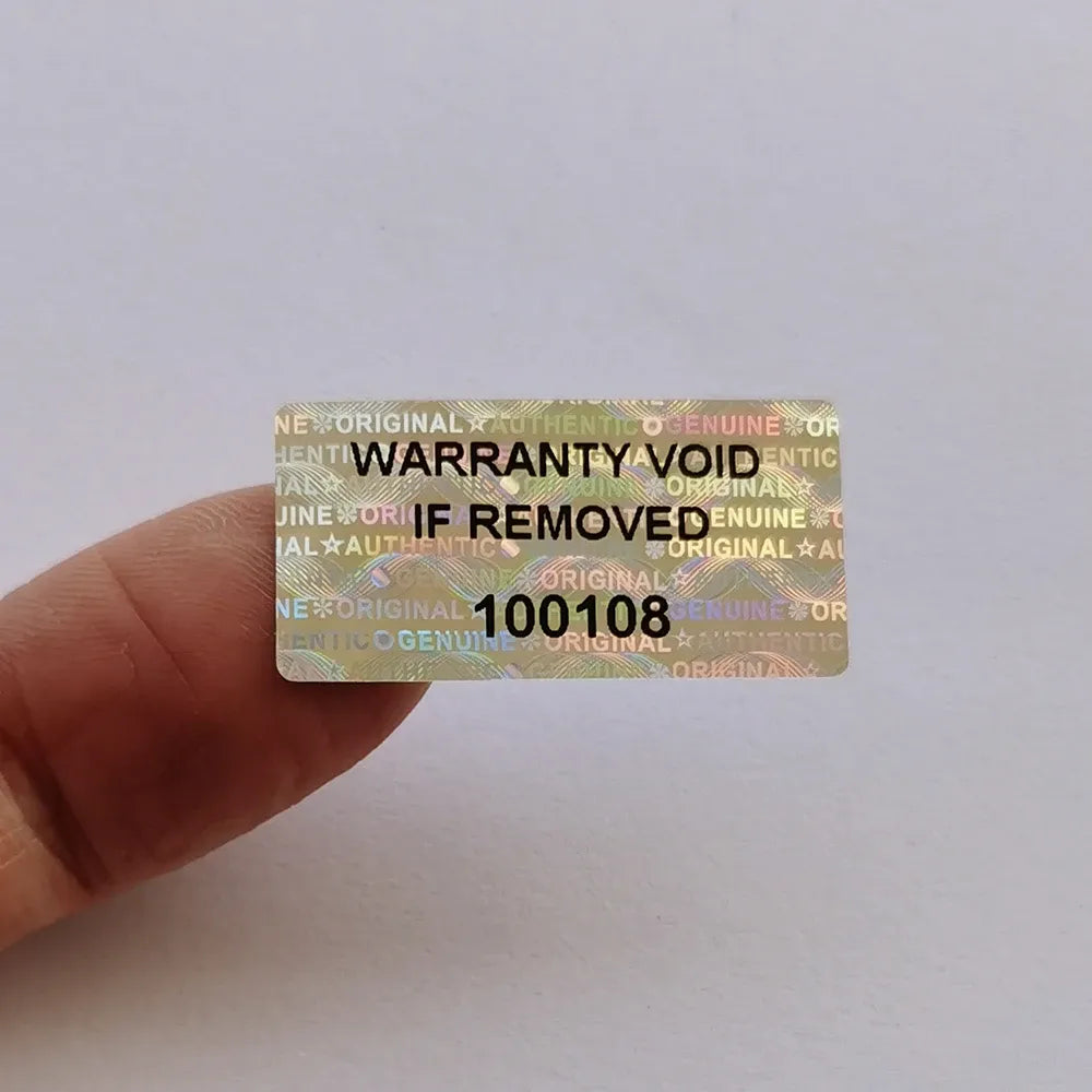 Hand holding holographic warranty void security label with serial number 100108