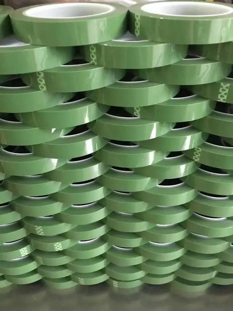 Green heat-resistant PET tape rolls stacked closely with adhesive edges