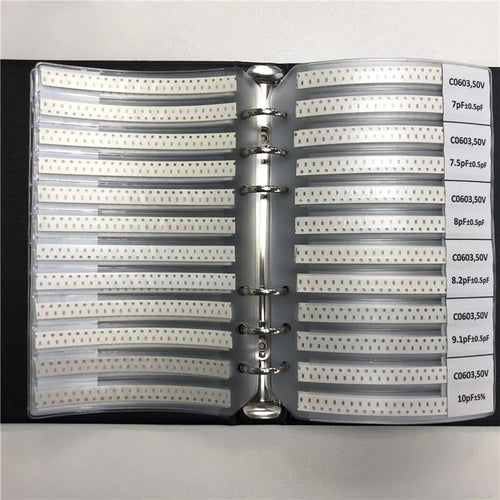 Capacitor sample binder open to two pages with labeled rows of component strips