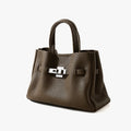 Taupe pebble grain leather handbag with top handles and a silver-tone classic metal lock closure, old money aesthetic.