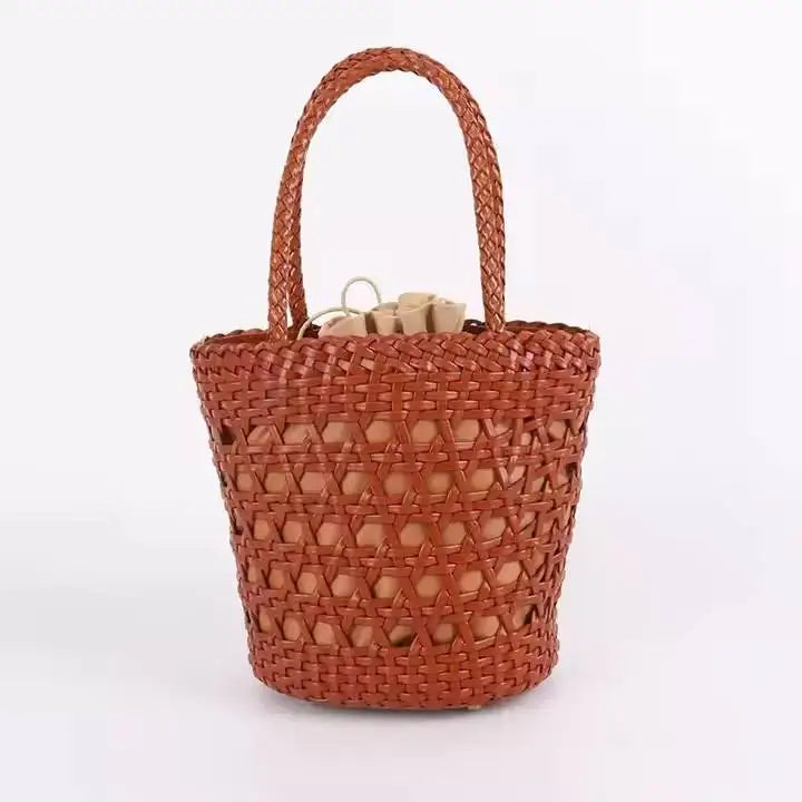 Tan handwoven leather bucket tote with cross-weave cannage design, braided handle, and drawstring interior pouch.
