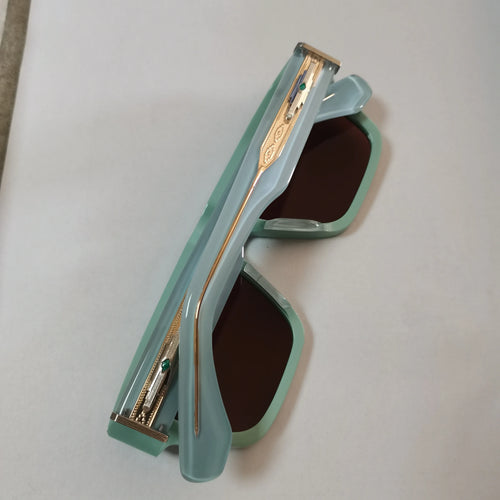 Luxury square sunglasses: pastel mint acetate frames, gold titanium temples, dark brown lenses, and elegant green details.