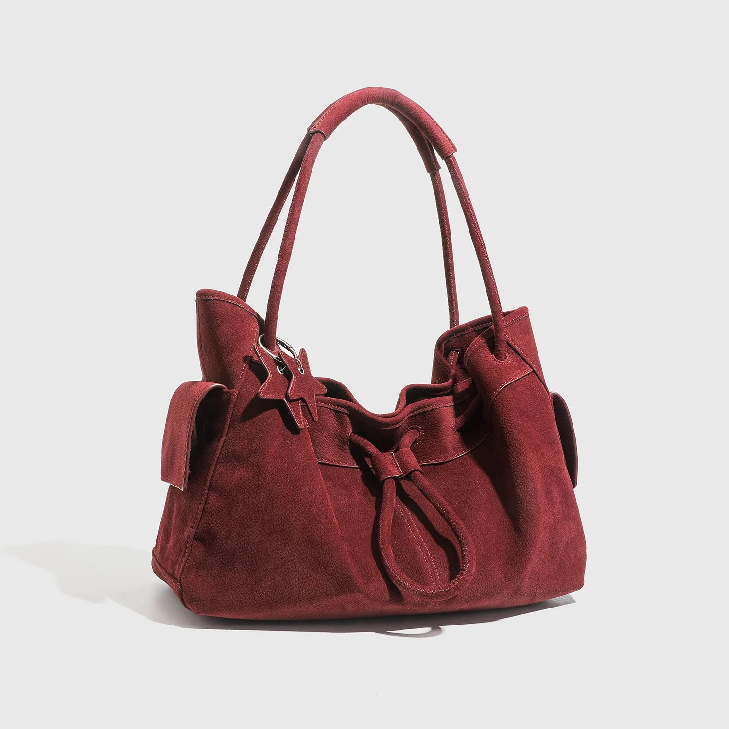 Deep red suede designer shoulder bag, large slouchy commuting tote with dual straps and side pocket details.
