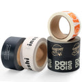 Assorted colored logo kraft paper tape rolls, including black and orange accents