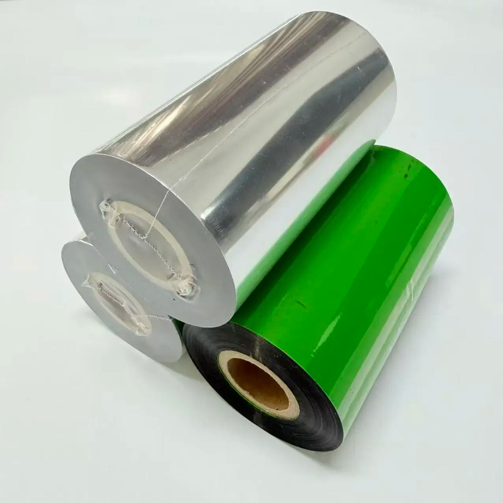 Wax thermal transfer ribbon rolls on cores; silver, black, and green ribbon