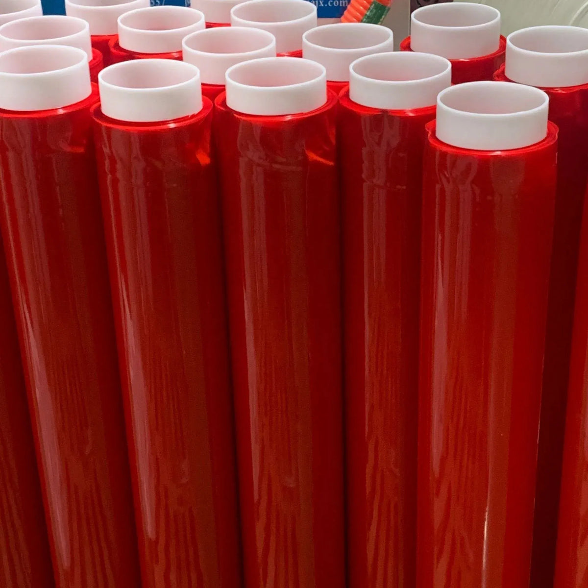 Red double-sided polyester tape rolls standing in a row with white inner cores
