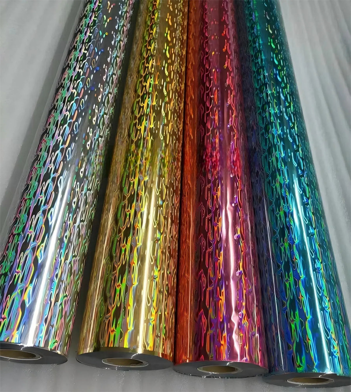 Iridescent holographic PVC film rolls in multicolor tones.