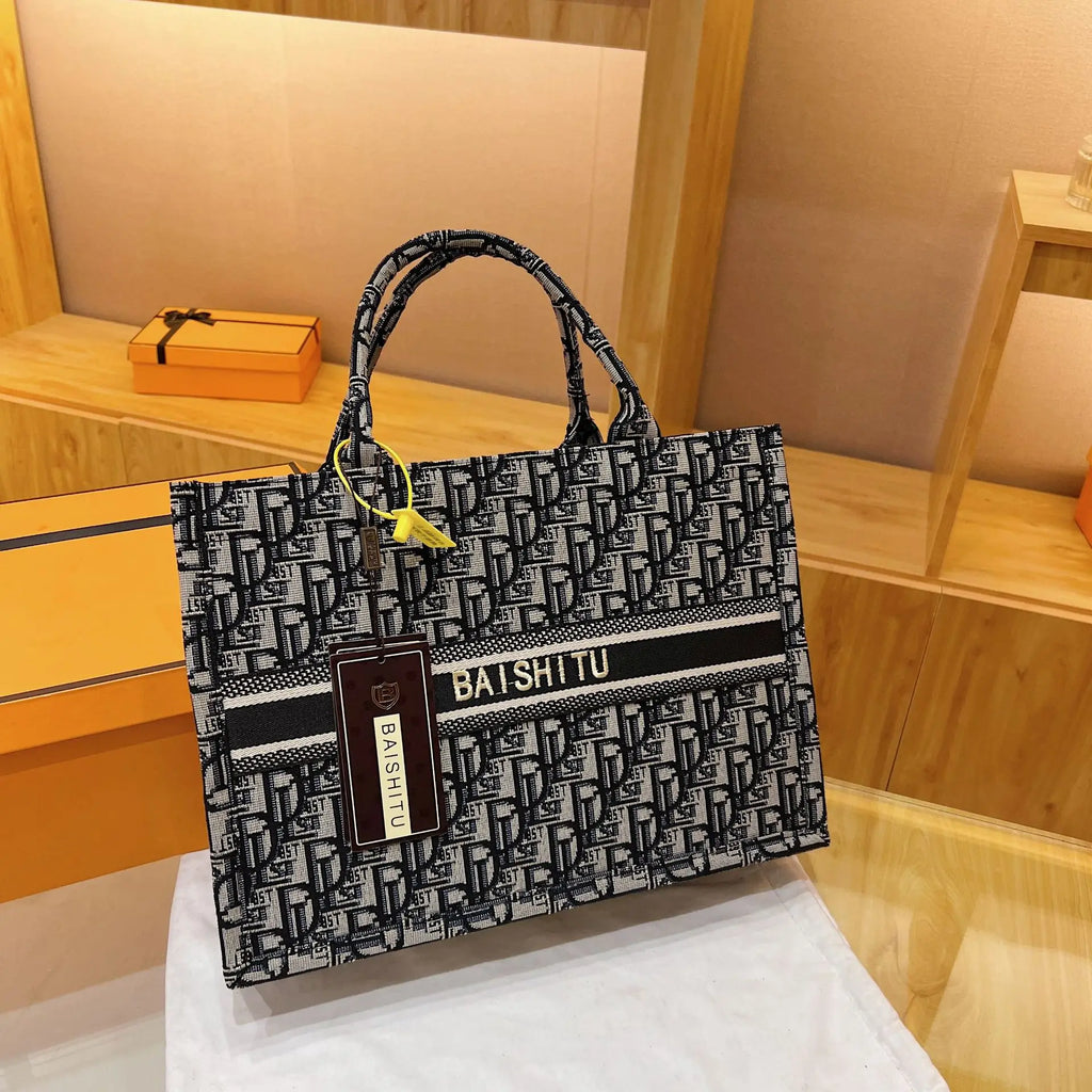 Black and white monogram canvas tote bag with Baishitu logo embroidery and top handles. Modern luxury trunk style.