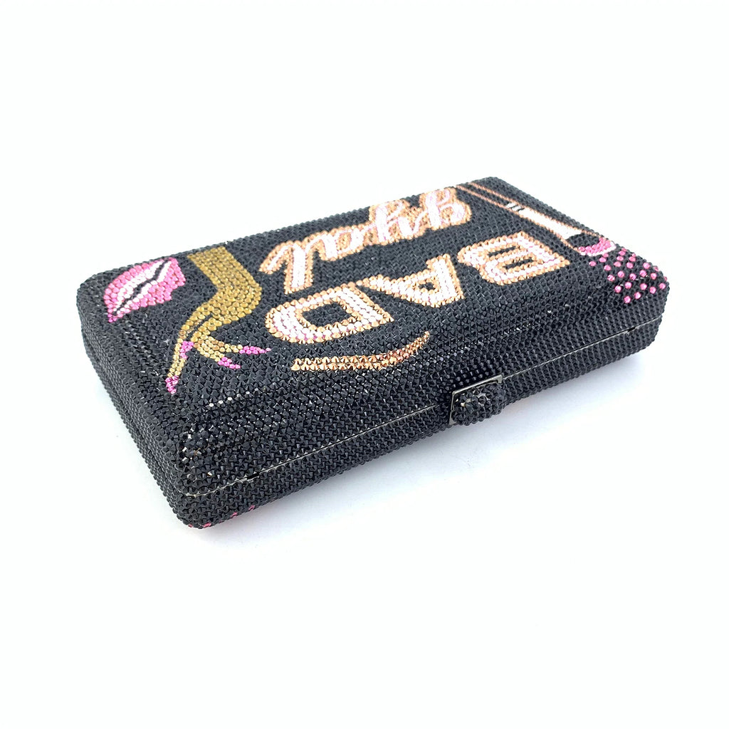 Black rhinestone designer clutch featuring "Bad Girl" lettering, pink lips, and gold accents for evening wear.