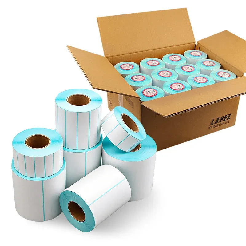Direct thermal label rolls stacked near a boxed shipment and spare label rolls
