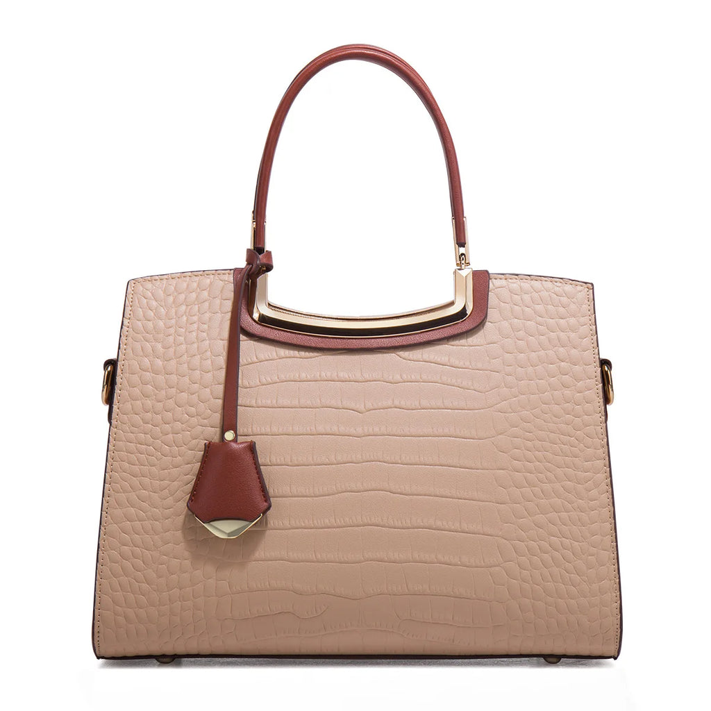 Beige crocodile-embossed leather tote bag with brown handles, gold metal trim, and a decorative leather pendant tag.