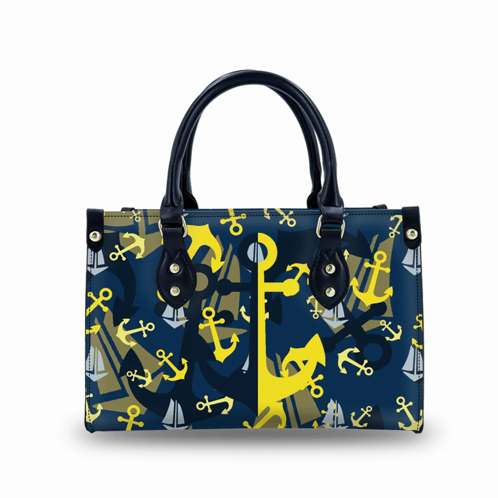 Navy genuine leather trunk handbag with yellow and white nautical anchor pattern, dual handles, and buckle details.