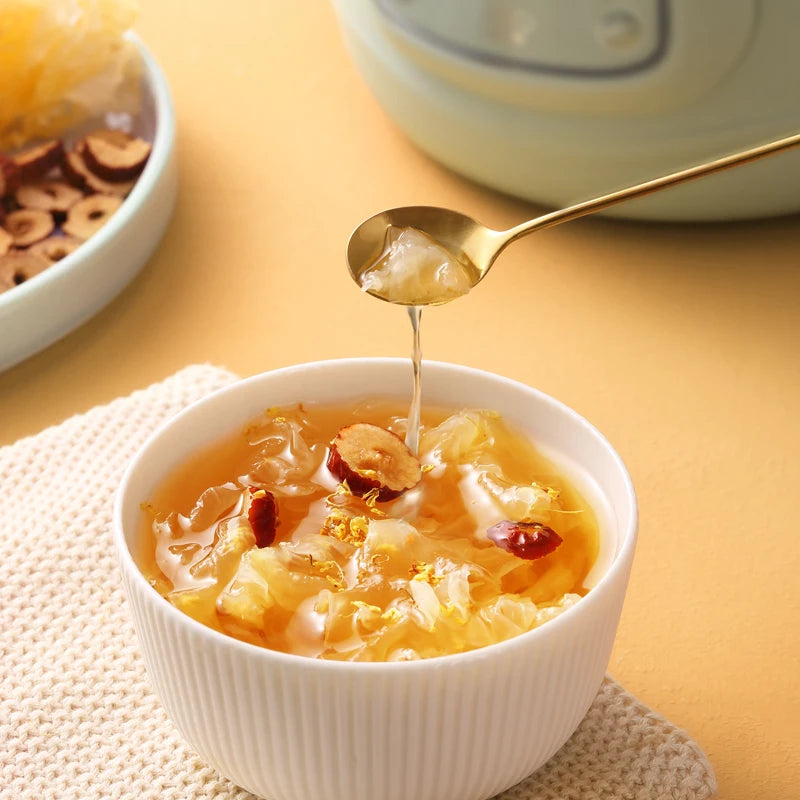 Electric slow cooker serving from spout, pouring soup into a white bowl