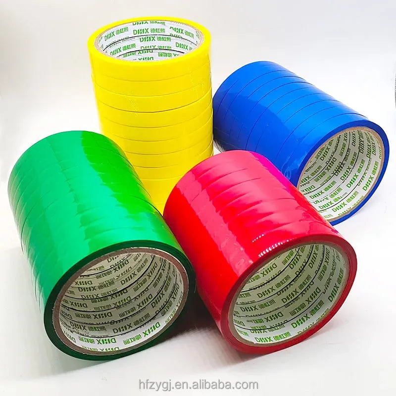 Bright colored strapping tape rolls in green, yellow, blue, and pink with printed cores