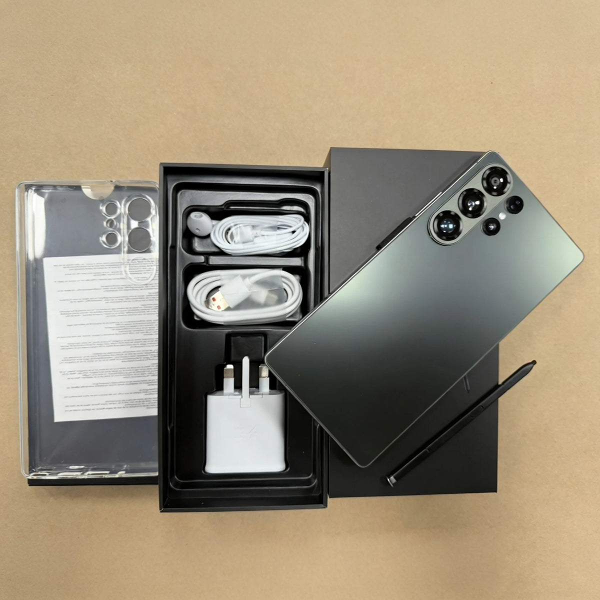 Unboxed S26 Ultra 5G smartphone set: phone back, cables, charger, and manual in box.