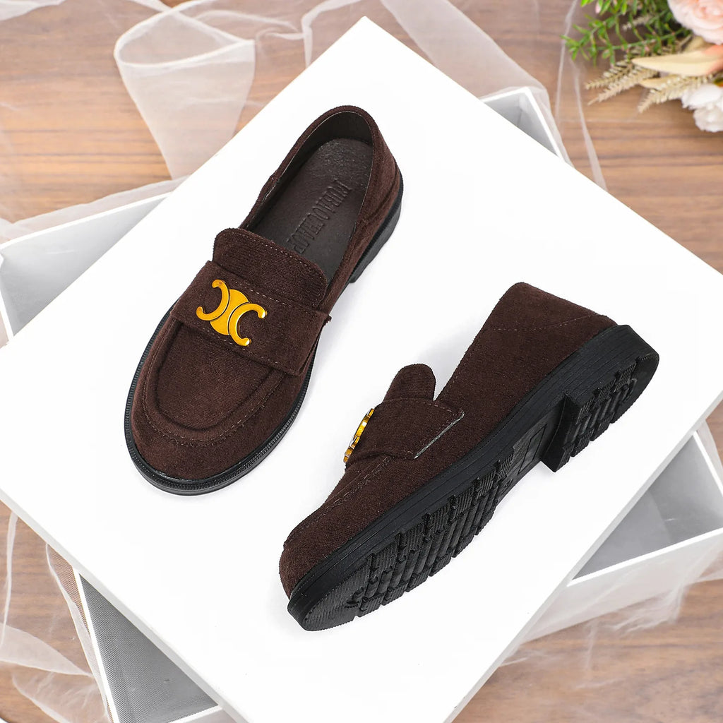 Dark brown suede women's loafers with gold emblem hardware and durable black lug soles on a white pedestal.