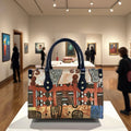 Fashionable trunk handbag with tribal print, PU leather, and navy handles displayed in a gallery.