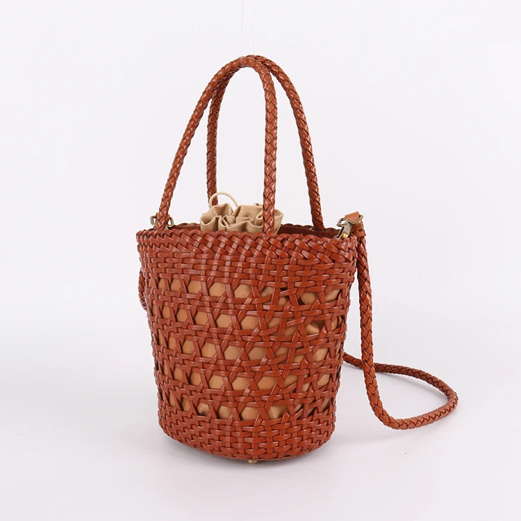 Tan handwoven leather bucket tote with cross-weave cannage design, braided handles, and beige drawstring pouch liner.