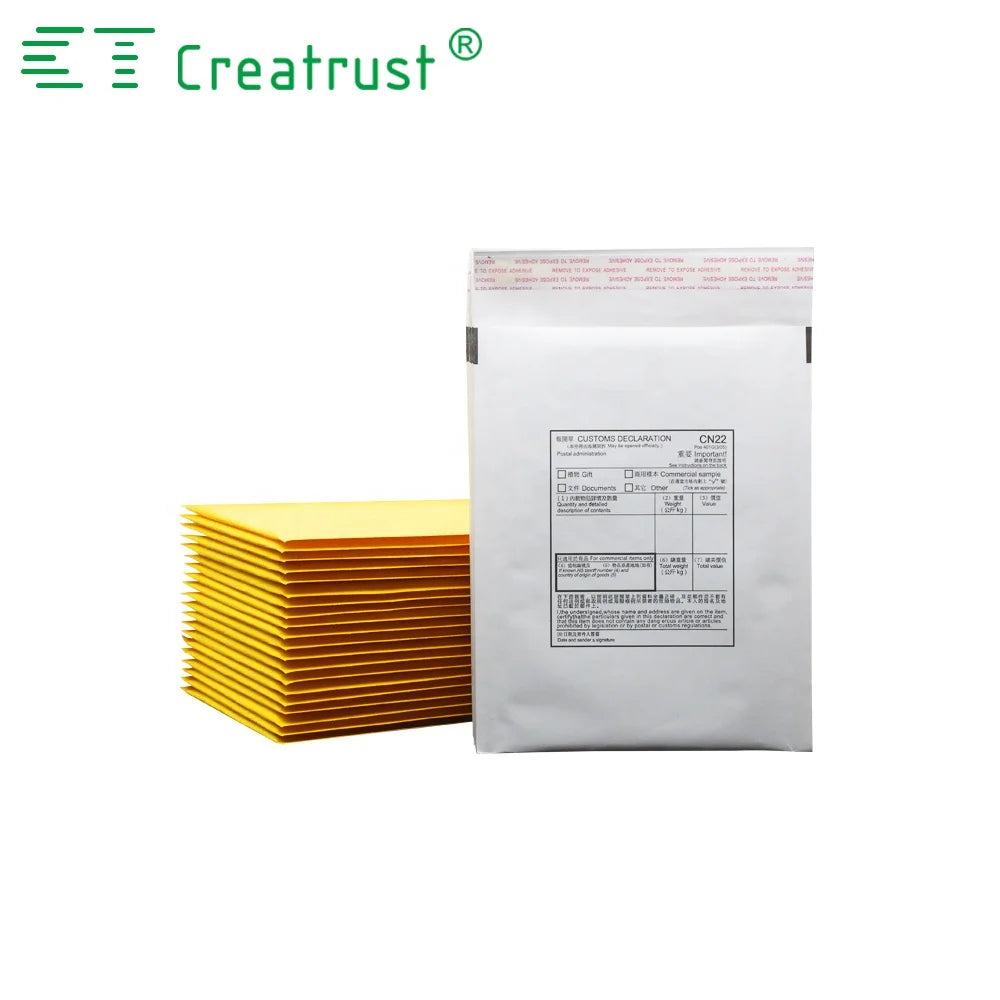 White padded mailer bag with printed label, backed by stacked yellow envelopes