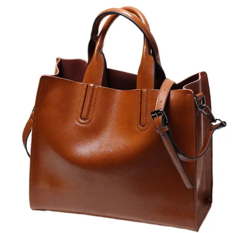 Tan genuine leather tote handbag with double handles, adjustable shoulder strap, and classic structured design for women.