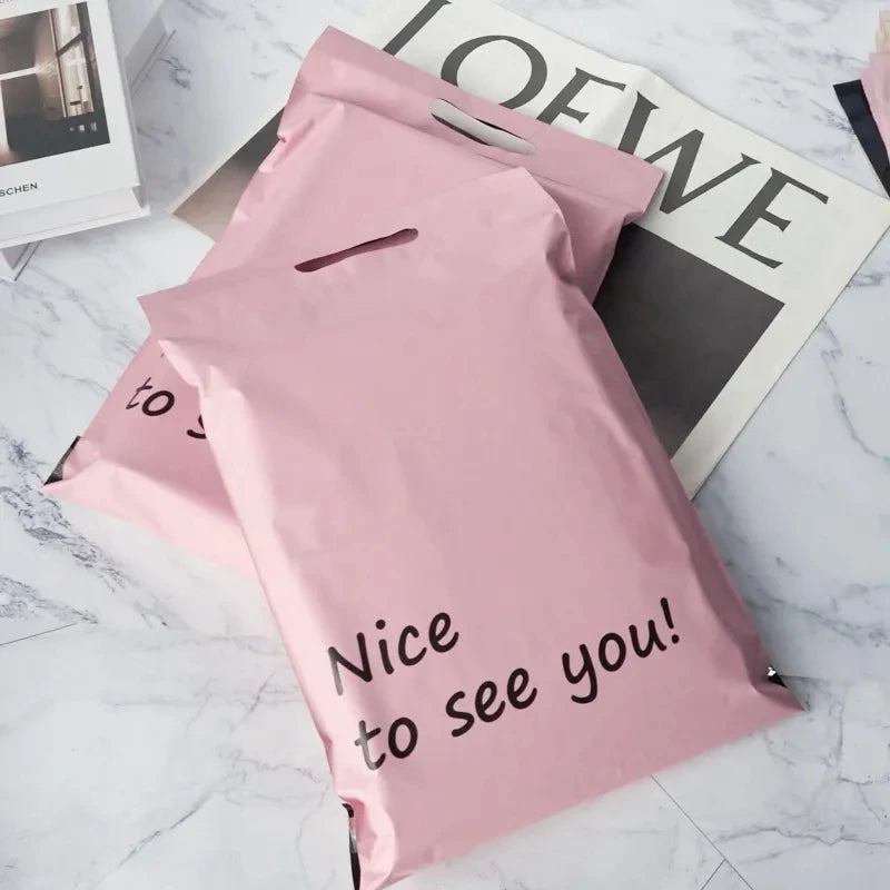 Pink poly mailer shipping bags with handle, showing “Nice to see you!” print