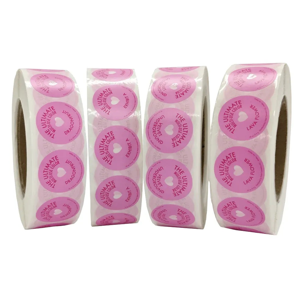 Stacked strips of pink round adhesive labels with repeated circular print