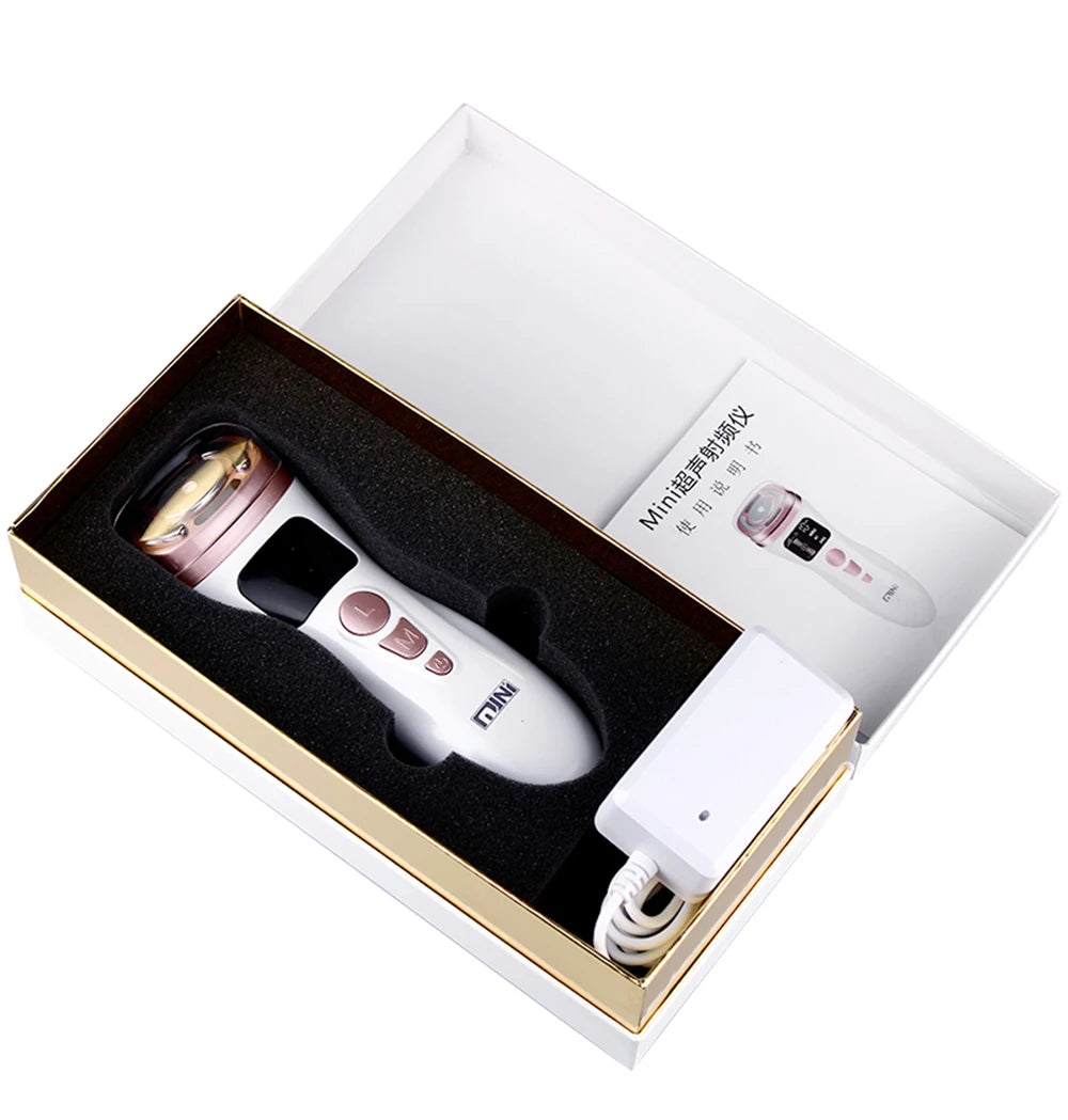 White and rose gold handheld HIFU facial device with charger and manual in a presentation gift box.