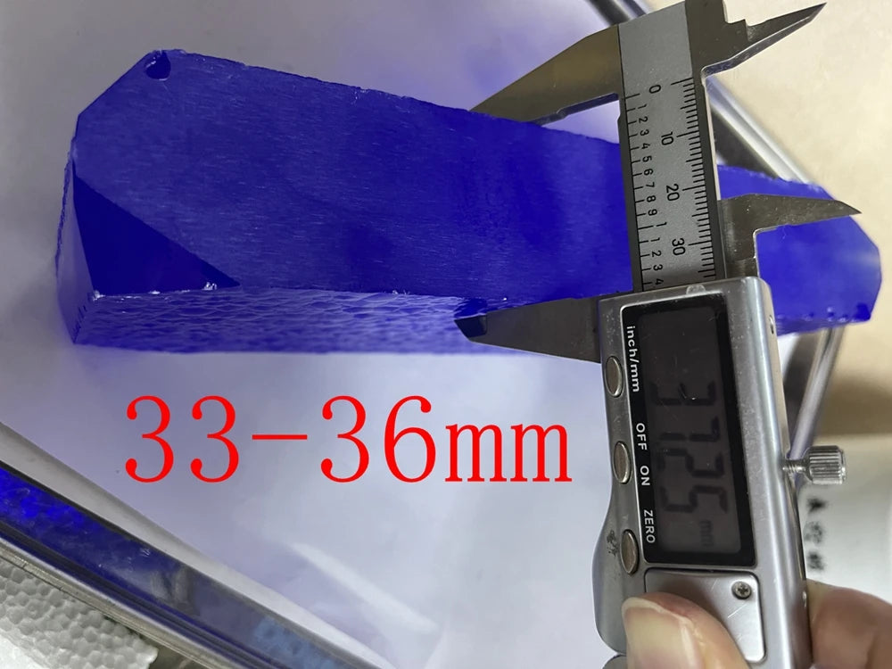 Blue synthetic hydrothermal crystal block, calipers measuring 33–36 mm thickness.