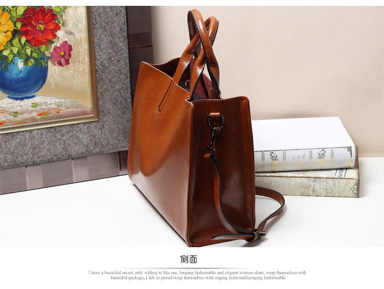 Tan genuine leather trunk handbag with structured sides, dual handles, and a detachable shoulder strap for women.