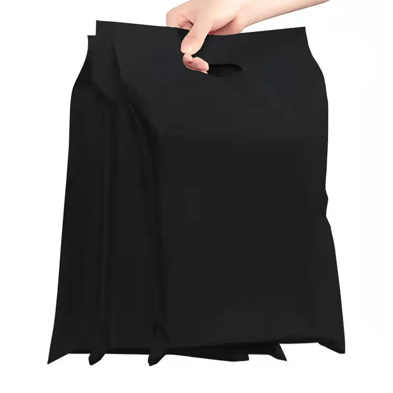 Black poly mailer bag with top handle cutout, held open by a hand