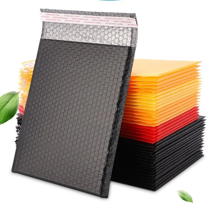 Black plastic bubble mailer envelopes stacked with printed red-and-blue strip on top