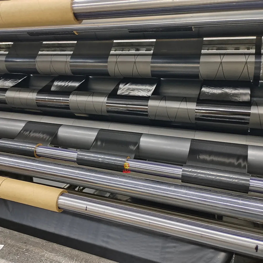 Stack of silver metallic vinyl sticker rolls on a printing machine